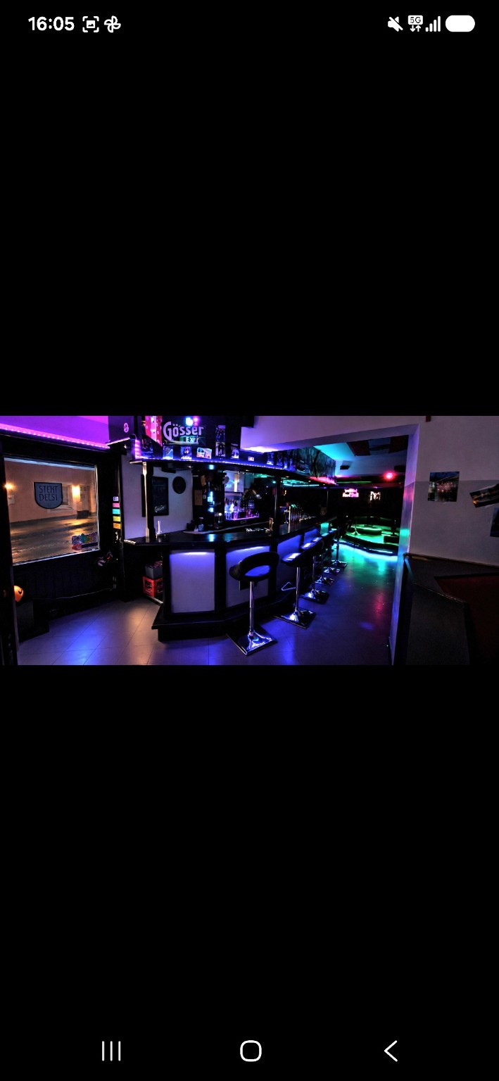 Blick entlang der beleuchteten Bar im Steh’Beisl